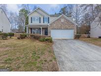 Charming two-story home with a brick facade, attached garage, and well-maintained front yard at 1886 Carisbrook Pl, Austell, GA 30168