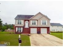Charming two-story home featuring a brick facade, two car garage, and well-maintained front lawn at 95 Revere Turn Drive, Fairburn, GA 30213