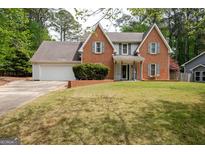 Charming two-story brick home with a well-manicured lawn and attached two-car garage at 112 Kirton Turn, Peachtree City, GA 30269