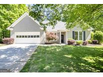 Charming single-story home with a well-manicured front yard and an attached two-car garage at 1155 Graystone Xing, Alpharetta, GA 30005