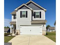 Charming two-story home featuring a two-car garage, gray siding, black shutters and well-manicured lawn at 458 Prescott Way, Villa Rica, GA 30180
