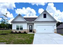 Charming one-story home with a two-car garage, green lawn and stylish front door at 601 Mackenzie Cove, Villa Rica, GA 30180