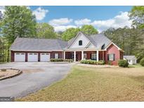 Charming brick home featuring a circular driveway and a spacious three-car garage, perfect for a growing Gathering at 270 Morrow Rd, Newborn, GA 30056