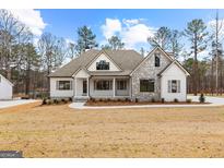 Charming home featuring a stone facade, siding, and manicured landscaping at 130 Windchime Way # 9, Tyrone, GA 30290