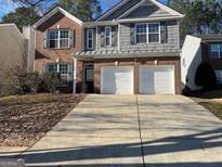 Charming two-story home with a brick and gray shingle exterior and a spacious two-car garage at 1870 Wildcat Trace Cir, Lawrenceville, GA 30043
