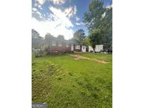 Charming single-story brick home with a spacious front yard and mature trees at 4111 Scott Dr, Forest Park, GA 30297