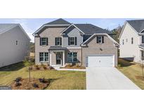 Charming two-story home featuring a brick facade, black shutters, and a well-manicured front lawn at 1809 Quaker, Hampton, GA 30228