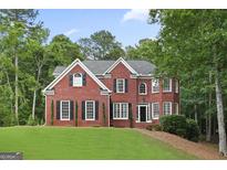 Classic brick home with a manicured lawn and mature trees at 240 Longmead Dr, Fayetteville, GA 30215