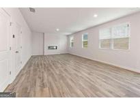 Spacious living room featuring hardwood floors, a fireplace, and ample natural light from large windows at 8501 Polston Pl # 143, Douglasville, GA 30134