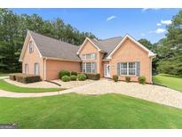 Charming brick home featuring manicured landscaping and a welcoming walkway leading to the front door at 1010 Elaine Ct, Mcdonough, GA 30252