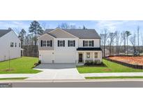 Two-story home featuring a three-car garage and classic black shutters, showcasing a well-manicured lawn at 1949 Van Allen Ct # 4, Dacula, GA 30019