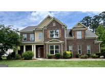 Charming two-story brick home with manicured lawn and inviting front entrance at 321 Champions Dr, Fairburn, GA 30213