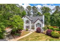 Charming two-story home featuring a well-manicured lawn, mature trees and lush landscaping at 9206 Denmeade Trce, Douglasville, GA 30135