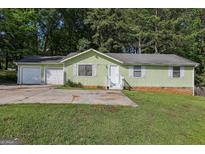 Charming single-story home featuring an attached two-car garage and a well-maintained front yard at 4954 Browns Mill Rd, Lithonia, GA 30038