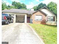 Charming single-story home with a brick facade, attached garage and concrete driveway at 3035 Landington Way, Duluth, GA 30096