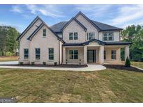 Beautiful new construction home featuring a covered porch, professional landscaping, and modern brickwork at 1465 Leach Dr, Lawrenceville, GA 30045