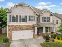 Charming home with stone accents, neutral siding, shutters, landscaped front yard, and two car garage at 3805 Alden Pl, Cumming, GA 30028