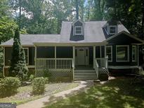 Charming home featuring a cozy front porch, well-maintained lawn, and mature trees at 686 Favorwood Sw Dr, Marietta, GA 30060