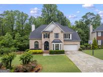 Charming brick home boasts a manicured lawn, lush landscaping, and a welcoming front entrance at 3924 Lorien Nw Way, Kennesaw, GA 30152