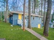 Quaint exterior view of home featuring a charming, painted blue facade with a bright yellow door at 4366 Glenwood Pkwy, Decatur, GA 30032