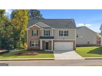 Charming two-story home featuring a combination of brick and siding, a two-car garage, and a well-manicured front lawn at 1940 Van Allen Ct # 12, Dacula, GA 30019