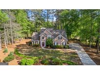 Charming two-story home features a well-manicured lawn, mature trees, and a welcoming red front door at 226 Le Paradis Blvd, Sharpsburg, GA 30277