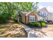 Charming townhome featuring a brick facade, well-maintained landscaping, and a cozy front entrance at 701 Ridgelake Dr, Peachtree City, GA 30269