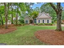 Charming single-story home boasts a beautifully landscaped front yard with lush green grass and mature trees at 229 Terrane Rdg, Peachtree City, GA 30269