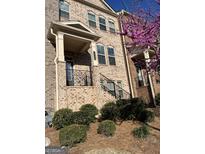 Charming brick townhome with landscaped front yard and a decorative black metal railing at 3608 Davenport Rd, Duluth, GA 30096