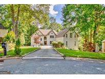 Stately two-story home boasts a sprawling driveway, lush landscaping, and a tranquil wooded setting at 1214 Weatherstone Way, Peachtree City, GA 30269