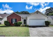Charming single-story home featuring a brick facade and a two-car garage with manicured lawn at 11367 Vinea Ln, Hampton, GA 30228