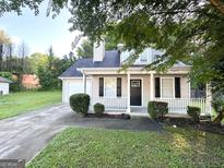 Charming home featuring a small front porch, attached garage, and well-maintained lawn at 614 Tramore Ct, Stockbridge, GA 30281