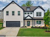 Charming two-story home featuring a mix of brick and siding, complemented by a well-manicured lawn at 5350 Woodline View Cir, Hoschton, GA 30548