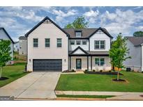 Charming two-story home featuring a brick facade, attached garage, and beautifully landscaped front yard at 5350 Woodline View Cir, Hoschton, GA 30548