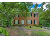 Charming two-story brick home with a well-maintained lawn and mature trees in a serene setting at 1201 Justin Ln, Lithonia, GA 30058