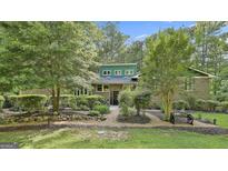 Charming brick home boasts lush landscaping, mature trees, and a welcoming front entrance at 120 Tall Pine Dr, Fayetteville, GA 30214
