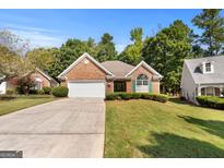 Charming single-story brick home with manicured lawn, a two-car garage, and mature trees in a desirable neighborhood at 1152 Strath Clyde Way, Mcdonough, GA 30253