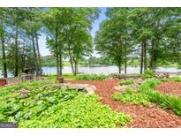 Lush backyard featuring a pond and landscaping with water views of the lake at 312 Flat Shoals Church Rd, Stockbridge, GA 30281
