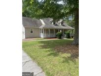 Charming home featuring a welcoming front porch, dormer windows, and a two-car attached garage at 145 County Line Ct, Fayetteville, GA 30215