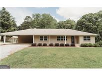 Inviting home with well-manicured lawn and classic architectural design with lovely landscaping at 8394 Banks Mill Rd, Douglasville, GA 30135