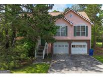 Charming two-story home with a two-car garage, framed by mature trees and a well-maintained lawn at 300 Fox Trail Dr, South Fulton, GA 30349