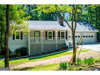 Charming single Gathering home with a manicured front lawn and a convenient two-car garage at 6026 Belle Meade Ct, Villa Rica, GA 30180