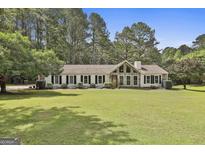 Charming ranch home features a spacious front yard, stone accents, and manicured landscaping at 150 Whitney Way, Fayetteville, GA 30214