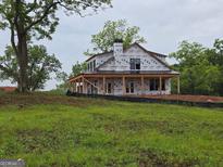 Charming farmhouse with a classic design and inviting front porch nestled in a serene country setting at 51 Alatus Rd, Hogansville, GA 30230
