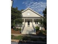 Charming two-story home with a large front porch, white siding and beautiful landscaping at 10583 Serenbe Ln, Palmetto, GA 30268