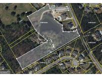 Aerial view of a large parcel of land with outlines, neighboring homes, a pond, and road access at 3136 Camp Branch Rd, Buford, GA 30519