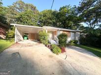 Ranch-style home with a carport, concrete driveway, and landscaped greenery at 2229 Sharon Way, Decatur, GA 30032