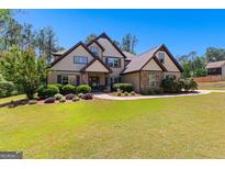 Charming home featuring a landscaped yard, stone accents, and a welcoming front entrance at 105 Turnberry Trce, Sharpsburg, GA 30277