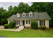 Charming single-story home featuring dormer windows, complemented by lush landscaping and a well-maintained green lawn at 170 River Forest Dr, Fayetteville, GA 30214