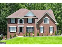 Charming brick home with black shutters, manicured lawn, and mature landscaping at 20 Allie Dr, Mcdonough, GA 30252